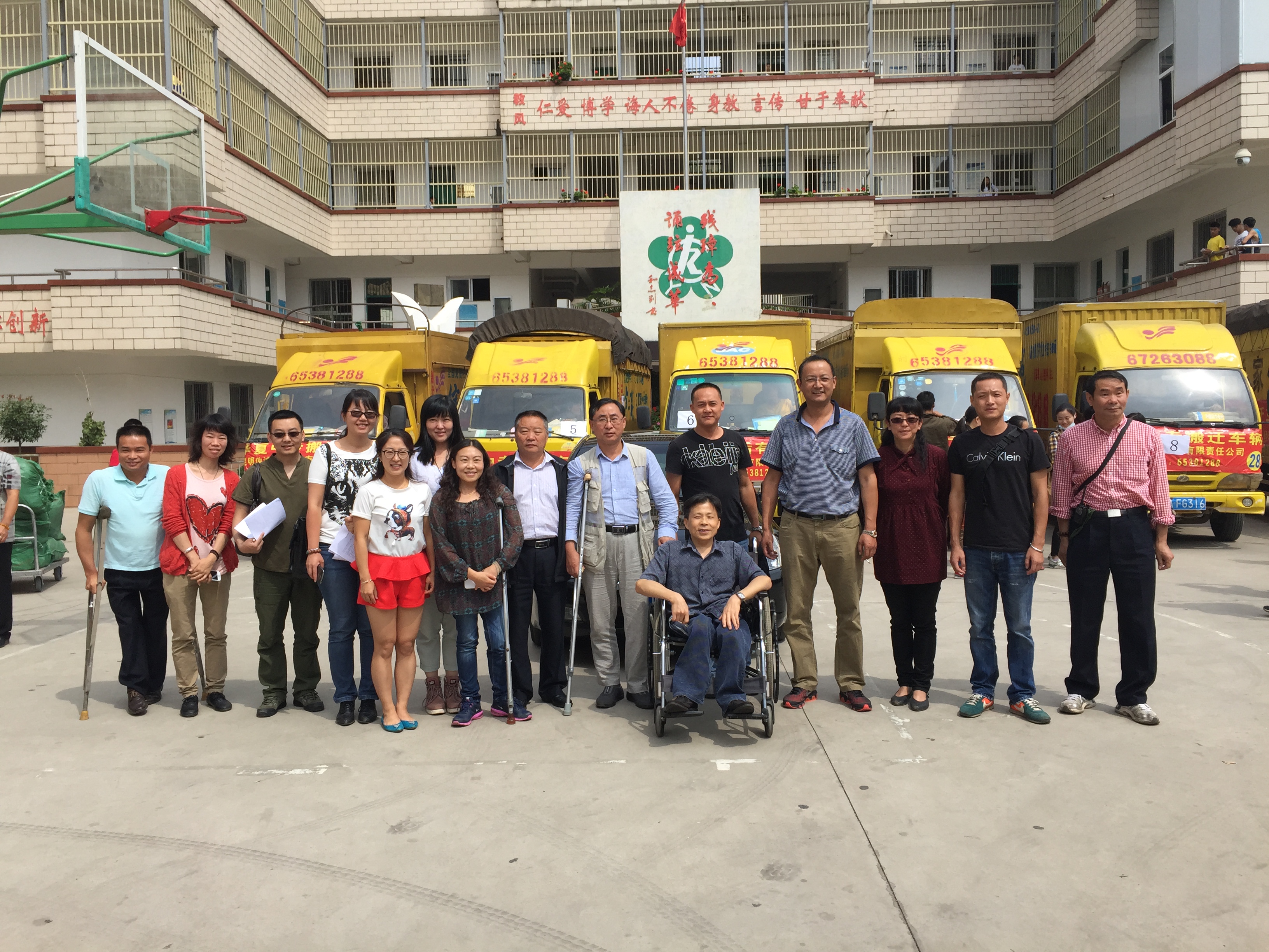 图为搬迁车辆出发前校领导和教师代表合影